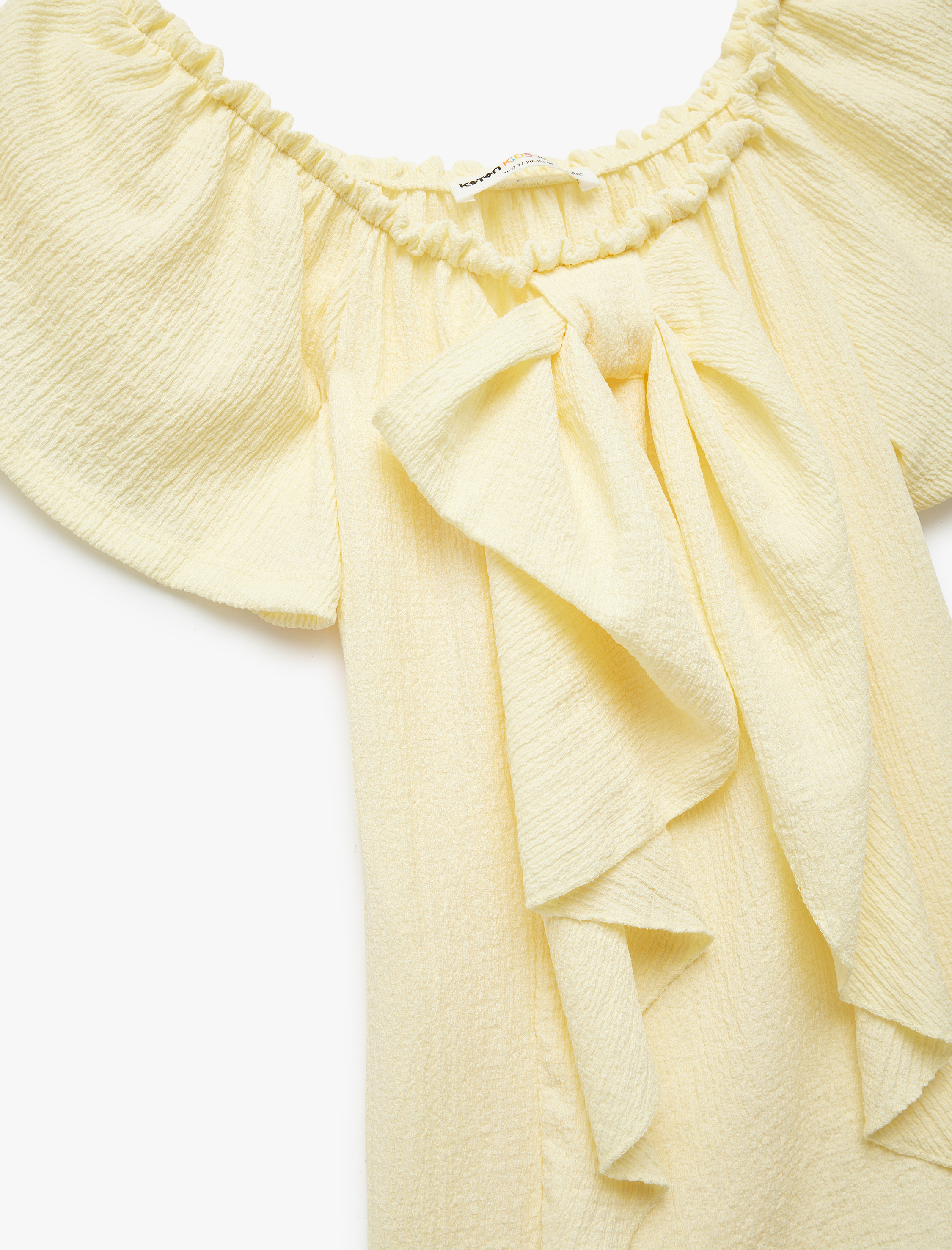  Kız Çocuk Bürümcük Kumaş Fiyonklu Omzu Açık Fırfırlı Kısa Kollu Bluz